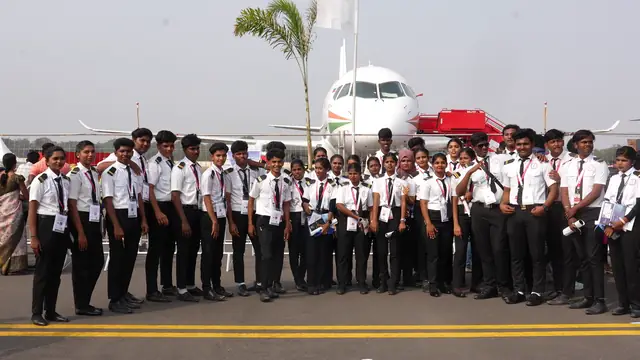 Aviation students in uniform on the airport apron beside an aircraft