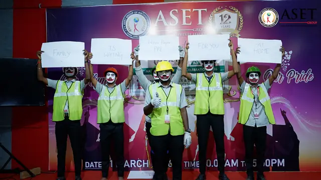 Fire and safety students performing a safety mime in high-visibility vests